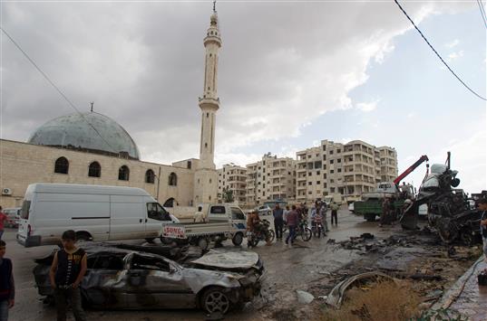 سيارة مدمرة جراء انفجار امام مسجد في منطقة يسيطر المسلحون عليها في ادلب امس (رويترز)