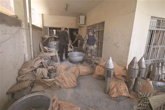 جنود عراقيون يتفقدون «مصنعاً» للصواريخ تابعاً لـ «داعش» في الفلوجة أمس (ا ف ب)