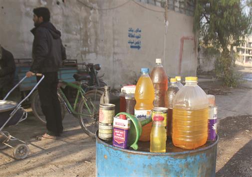 شاب يبيع البنزين في عربين في ريف دمشق في 10 كانون الأول الحالي (رويترز)