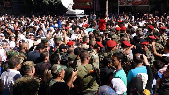سوريون يشاركون في مسيرة حكومية في قدسيا امس (أ ب أ)