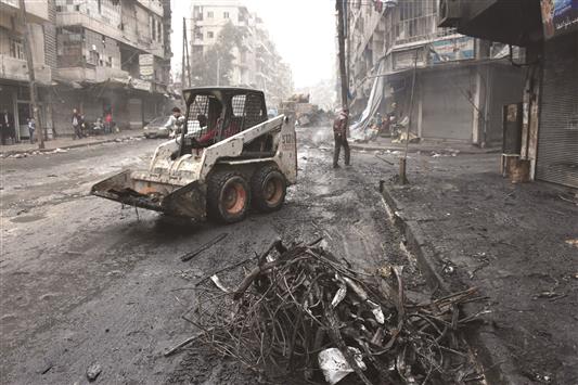 الحكومة السورية تبدأ عملية إزالة الركام من احد احياء حلب أمس (ا ف ب)