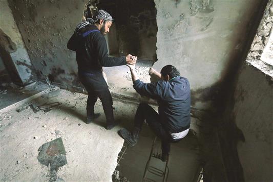 مسلحان داخل مبنى في حي العامرية في حلب امس (رويترز)