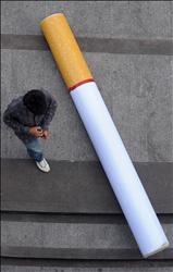 تايلاندي يمر بقرب سيجارة عملاقة، في اطار حملة «الامتناع عن التدخين» في تايلاند، أمس..
