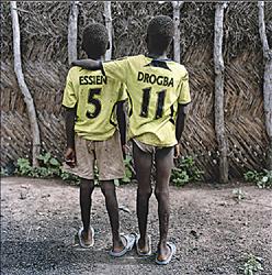 توأمان من غانا، يرتديان قمصاناً كتبت عليها اسما لاعبين أفريقيين يلعبان في نادي تشيلسي.
