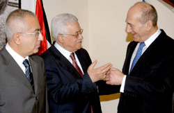 عباس متوسطاً أولمرت وفياض خلال اجتماع في القدس المحتلة
