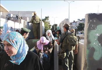 فلسطينيات ينتظرن العبور من بيت لحم إلى القدس المحتلة لإحياء ليلة القدر في المسجد الأقصى، أمس