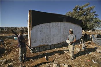 مستوطنون يقومون بأعمال بناء في مستوطنة معاليه ميغرون في الضفة الغربية أمس