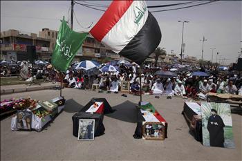 أتباع التيار الصدري يجلسون أمس وراء توابيت رمزية لقتلى تفجيرات استهدفت مصلين في مدينة الصدر الأسبوع الماضي