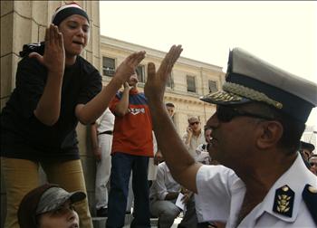 ناشطة مصرية تجادل شرطياً أثناء مشاركتها في تظاهرة أمام محكمة مصرية في القاهرة، احتجاجاً على توقيف ناشطين في مجموعة »٦ أبريل