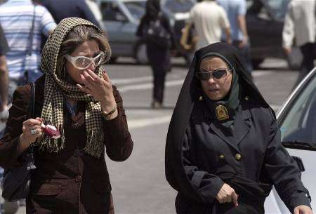شرطية إيرانية (إلى اليمين) تحذر امرأة بشأن ملابسها وظهور شعرها في إطار حملة تشنها الشرطة الايرانية على الملابس وسائر صيحات الموضة التي تعتبرها مخالفة للقيم الاسلامية.