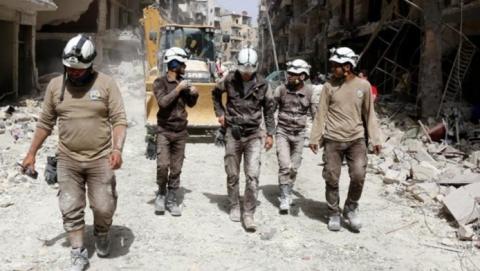  عناصر من “الخوذ البيضاء” خلال نقلهم شحنة متفجرات بسيارة إسعاف في ريف حماة .
