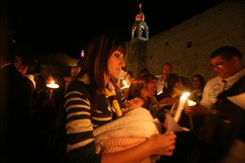 فلسطينيون مسيحيون يشعلون الشموع خلال قداس في كنيسة المهد في بيت لحم أمس لضحايا مجزرة كنيسة سيدة النجاة في بغداد