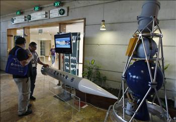 إسرائيليان يتفحصان أحد نماذج صاروخ «حيتس 3» في معرض الفضاء في القدس المحتلة أمس