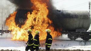 شاحنة نفط تحترق، فيما يحاول عمال الإنقاذ إطفاء الحريق