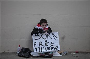 مناصر لـ«ويكيليكس» يرفع لافتة كتب عليها «ولدت مفكراً حراً» أمام المحكمة في لندن أمس الأول (