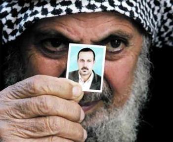 والد الشهيد المبحوح يحمل صورته في غزة بُعيد الكشف عن اغتياله في كانون الثاني الماضي