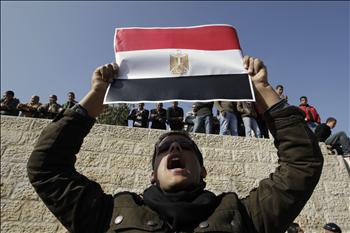 متظاهر يرفع العلم المصري أمام بوابة دمشق في القدس المحتلة أمس