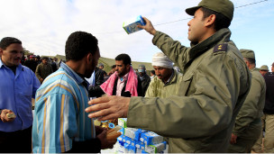 جندي تونس على الحدود التونسية الليبية يوزع الحليب على اللاجئين من ليبيا
