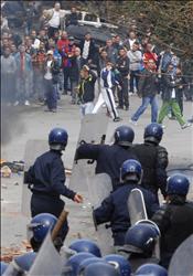 عناصر من مكافحة الشغب الجزائرية يشتبكون مع محتجين في العاصمة أمس 