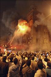 مصريون يتجمعون أمام كنيسة اشتعلت فيها النيران في امبابة فجر أمس (أ ب) 