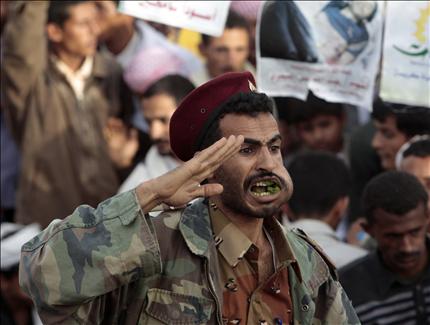 جندي يمني يمضغ القات يقدم التحية خلال تظاهرة ضد صالح في صنعاء امس (رويترز) 