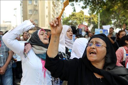 مسيحيات ومسلمات يتظاهرن أمام مقر التلفزيون في القاهرة أمس (أ ف ب) 