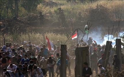 شبان سوريون وفلسطينيون في مواجهة جنود الاحتلال الإسرائيلي في الجولان المحتل أمس (رويترز) 
