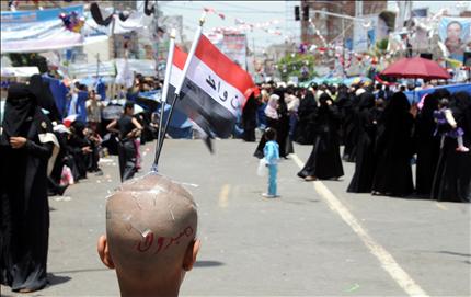 يمني يحمل علم بلاده وعلى رأسه كلمة «مبروك» خلال احتفال محتجين في صنعاء أمس بوجود صالح في السعودية (أ ب أ) 