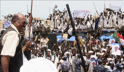 الرئيس السوداني عمر البشير يلوح لمناصريه في قرية في ولاية البحر الاحمر امس (رويترز) 