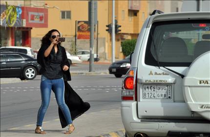 سعودية تلتقط صورة لامرأة تقود سيارة في الرياض أمس (أ ف ب) 
