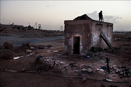 عنصر من الثوار يقف فوق اخر نقطة تفتيش في القواليش غرب ليبيا امس (ا ف ب) 