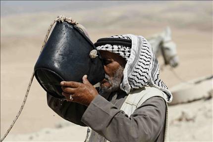 بدوي يشرب من مياه الصهاريج المهددة بالتدمير في الرشايدة قبل ايام (رويترز) 