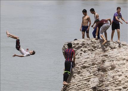 مصطفى محمود (16 عاما) يقفز في نهر دجلة لتبريد جسده من شدة الحر في العاصمة العراقية بغداد (أ ب) 