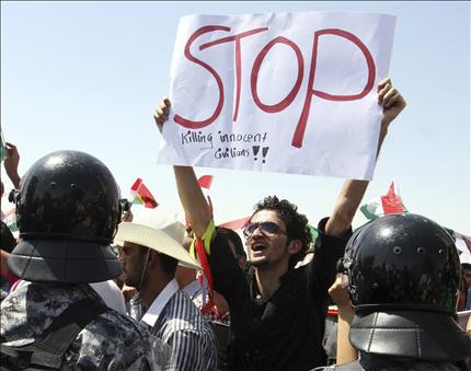 متظاهر امام القنصلية التركية في أربيل أمس، يحمل في يده لافتة كتب عليها «توقفوا»، وذلك احتجاجاً على القصف التركي على شمال العراق. (رويترز) 