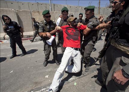 جنود الاحتلال يعتقلون متظاهراً قرب حاجز قلنديا أمس (أ ب أ) 