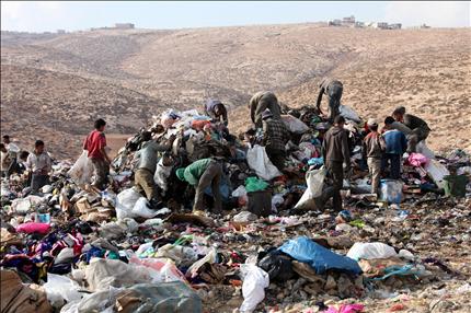 فلسطينيون يبحثون بين القمامة قرب الخليل امس (ا ب ا) 