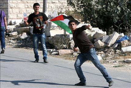 فلسطينيان يرشقان جنود الاحتلال بالحجارة خلال تظاهرة ضد الاستيطان في بلدة المعصرة في الضفة الغربية (ا ب ا) 