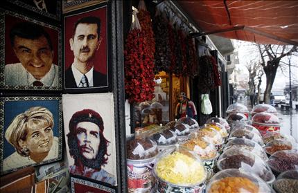 حلويات وصور للاسد وغيره في محل في مدينة كيليس التركية قرب الحدود السورية في 13 كانون الثاني الحالي (رويترز) 