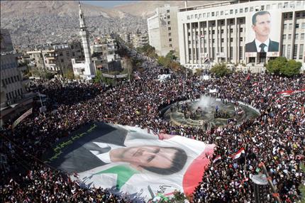 سوريون موالون للأسد يتظاهرون دعماً له ورفضاً لعقوبات الجامعة العربية في دمشق أمس (أ ف ب) 