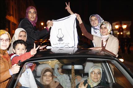 مغربيات يحتفلن بعد الإعلان عن فوز حزب "العدالة والتنمية"، ويحملن لافتة رسم عليها مصباح، الرمز الذي تبناه الحزب في الانتخابات التشريعية. (رويترز) 