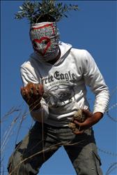 ناشط فلسطيني يستعد لرمي الحجارة على جنود الاحتلال في الضفة الغربية المحتلة أمس (أ ف ب) 