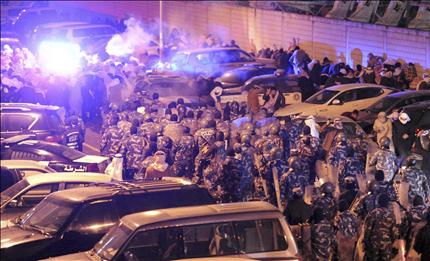 شرطيون كويتيون يشتبكون مع قبليين امام قناة «الوطن» في الكويت العاصمة، مساء أول امس (رويترز) 