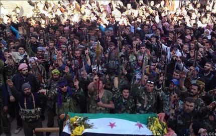 صورة وزعتها «لجان التنسيق المحلية» في سوريا أول أمس لمسلحين خلال تشييع قتيل في إدلب (أ ب) 