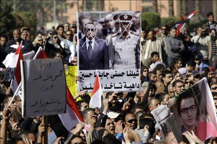 متظاهرون يرفعون لافتات ضد الحكم العسكري في ميدان التحرير أمس (أ ب) 