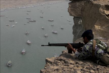 جندي إيراني يشارك في المناورات العسكرية في منطقة مضيق هرمز أمس (رويترز) 