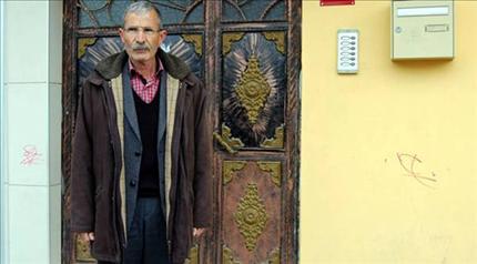 مواطن علوي أمام منزله وإشارة حمراء على الحائط 