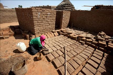 صورة وزعتها قوات السلام الافريقية امس لسودانية تصنع حجارة من الطوب لبناء منزل في مخيم للنازحين في شمال دارفور (ا ف ب) 