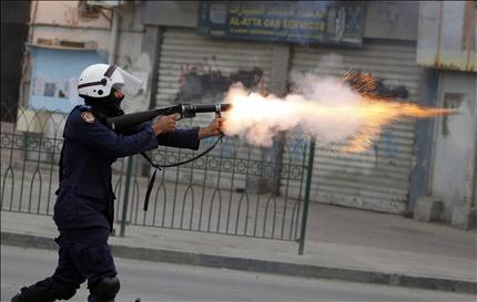 شرطي بحريني يطلق قنبلة غاز خلال تظاهرة للمعارضة في البلاد القديم أمس 