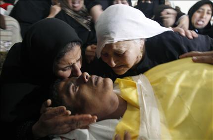 فلسطينيتان تنتحبان فوق جثمان شاب قتلته قوات الاحتلال في غزة أمس (أ ف ب) 