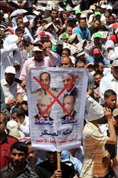 متظاهرون يرفعون لافتة ضد العسكر والفلول في ميدان التحرير أمس (أ ب أ) 